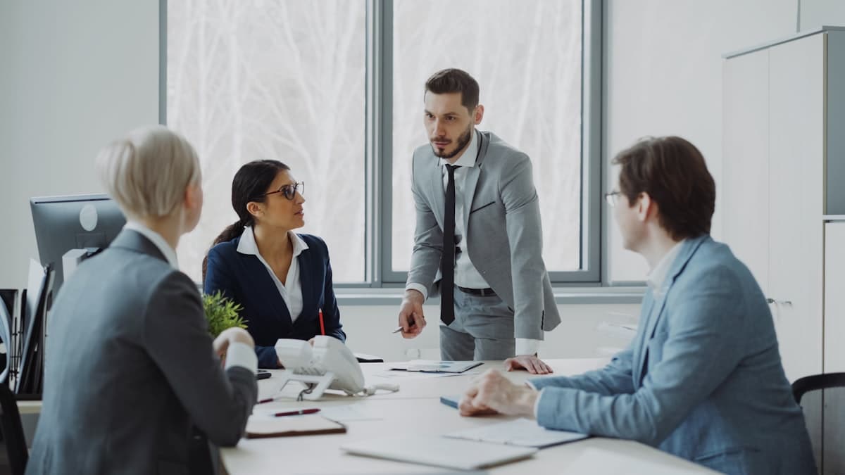 Executivos em reunião de negócios ao redor de uma mesa discutindo estratégia corporativa
