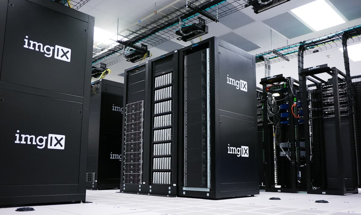 Corredor de racks de servidores em um data center, representando a infraestrutura de computação por trás dos investimentos em IA