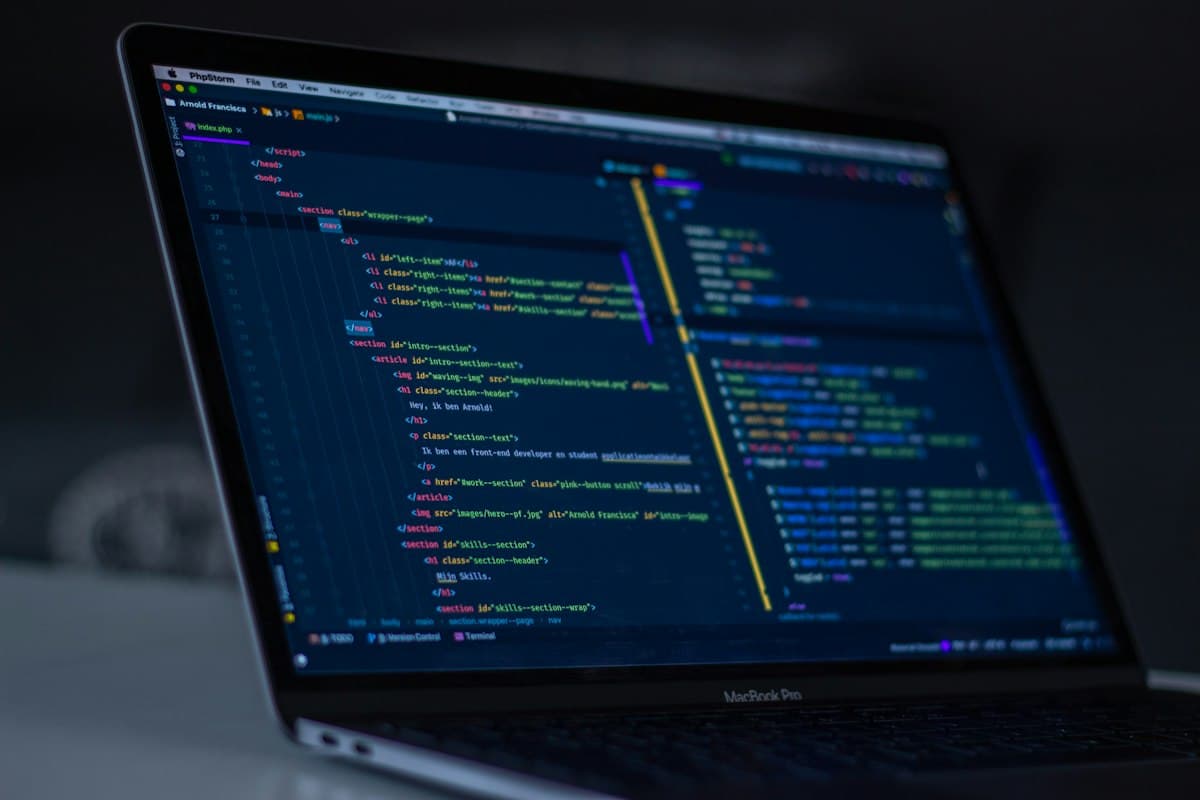 Laptop aberto exibindo código de programação em um editor