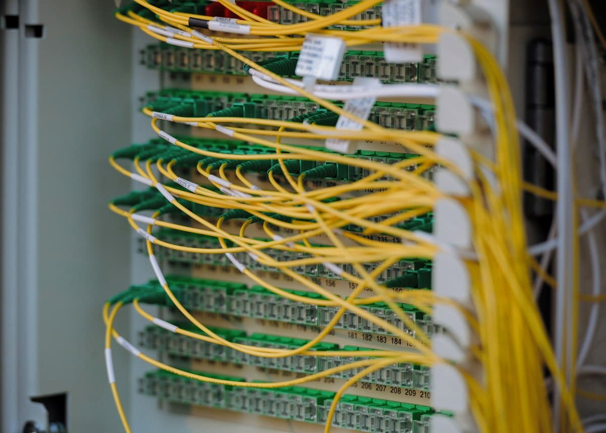 Cabos de rede amarelos e verdes organizados em um rack de data center